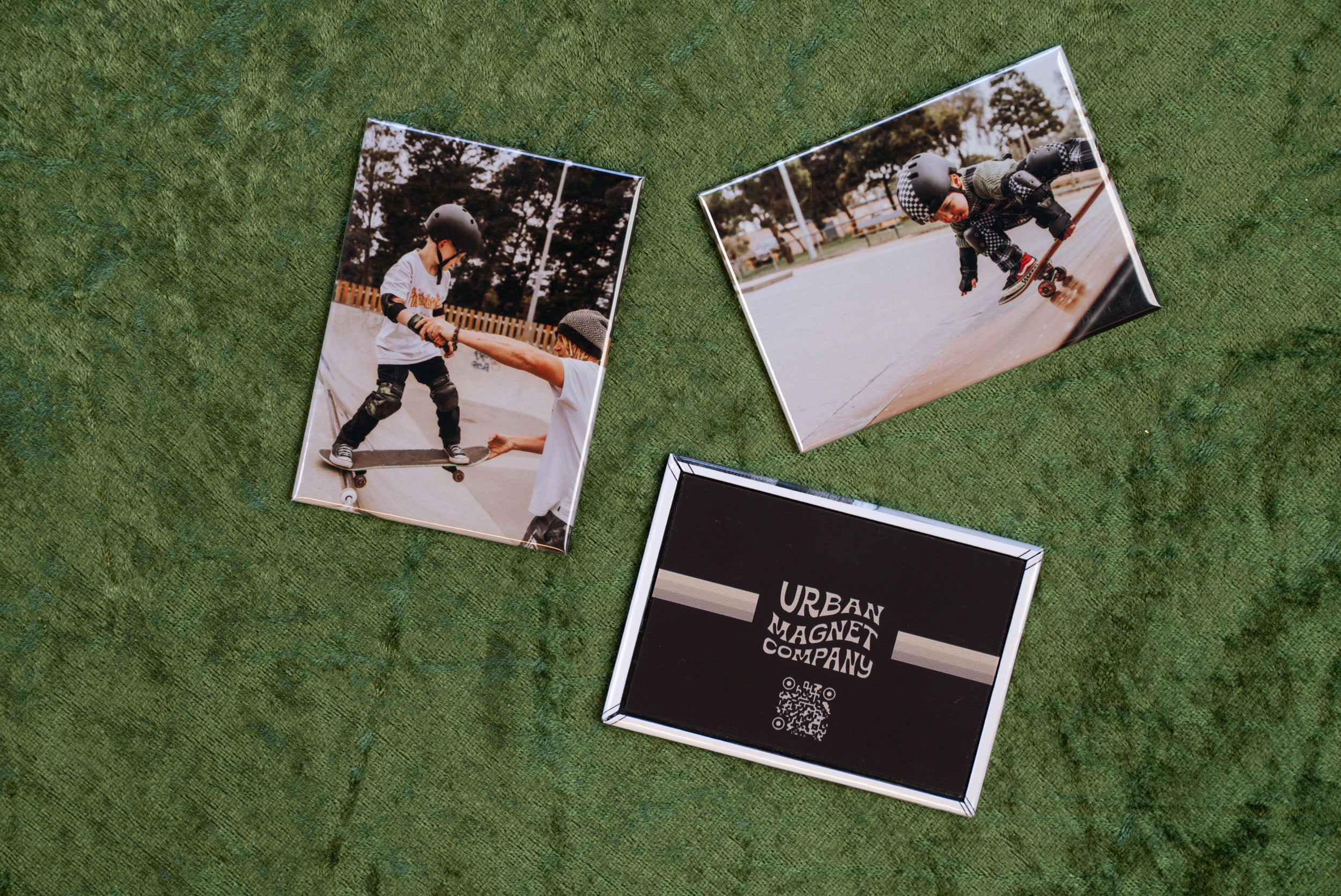 Various magnets with custom prints displayed on a green background.
