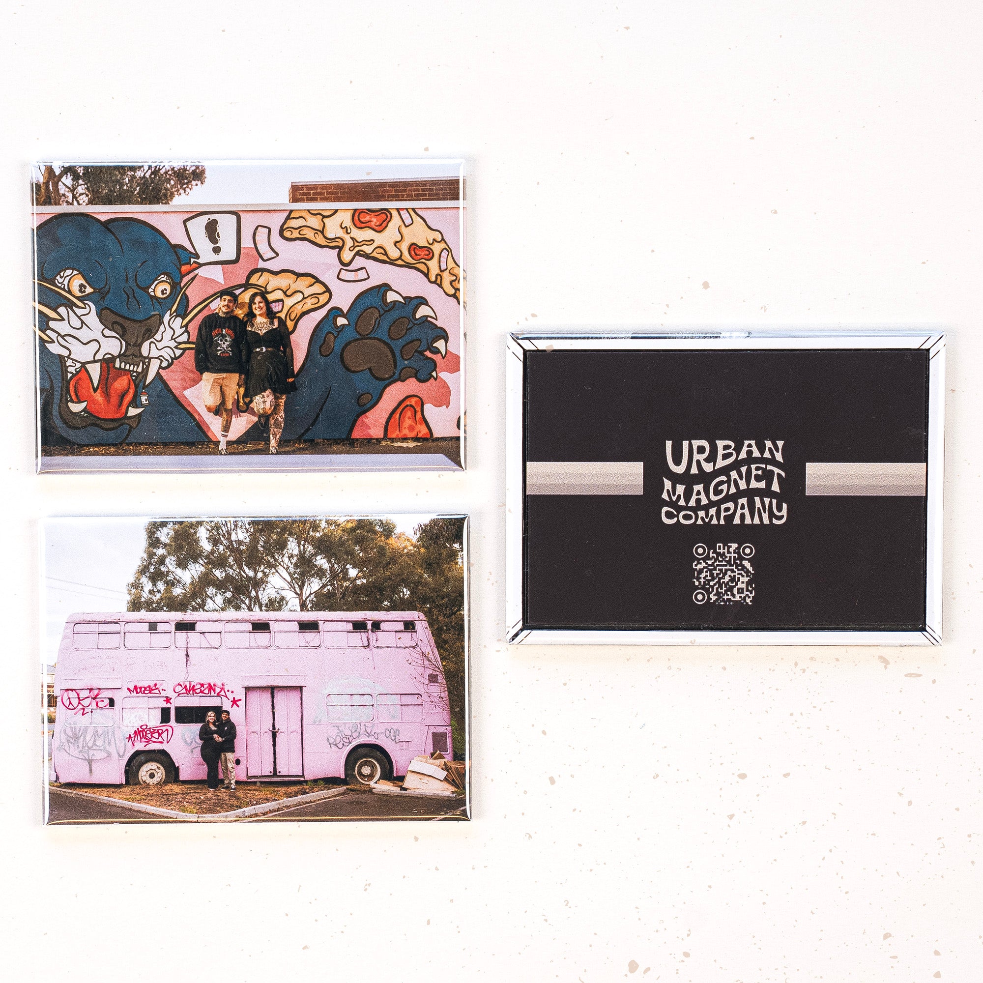 Three magnets displayed on a white background, two printed with photos of a couple and one printed with the Urban Magnet Co logo.