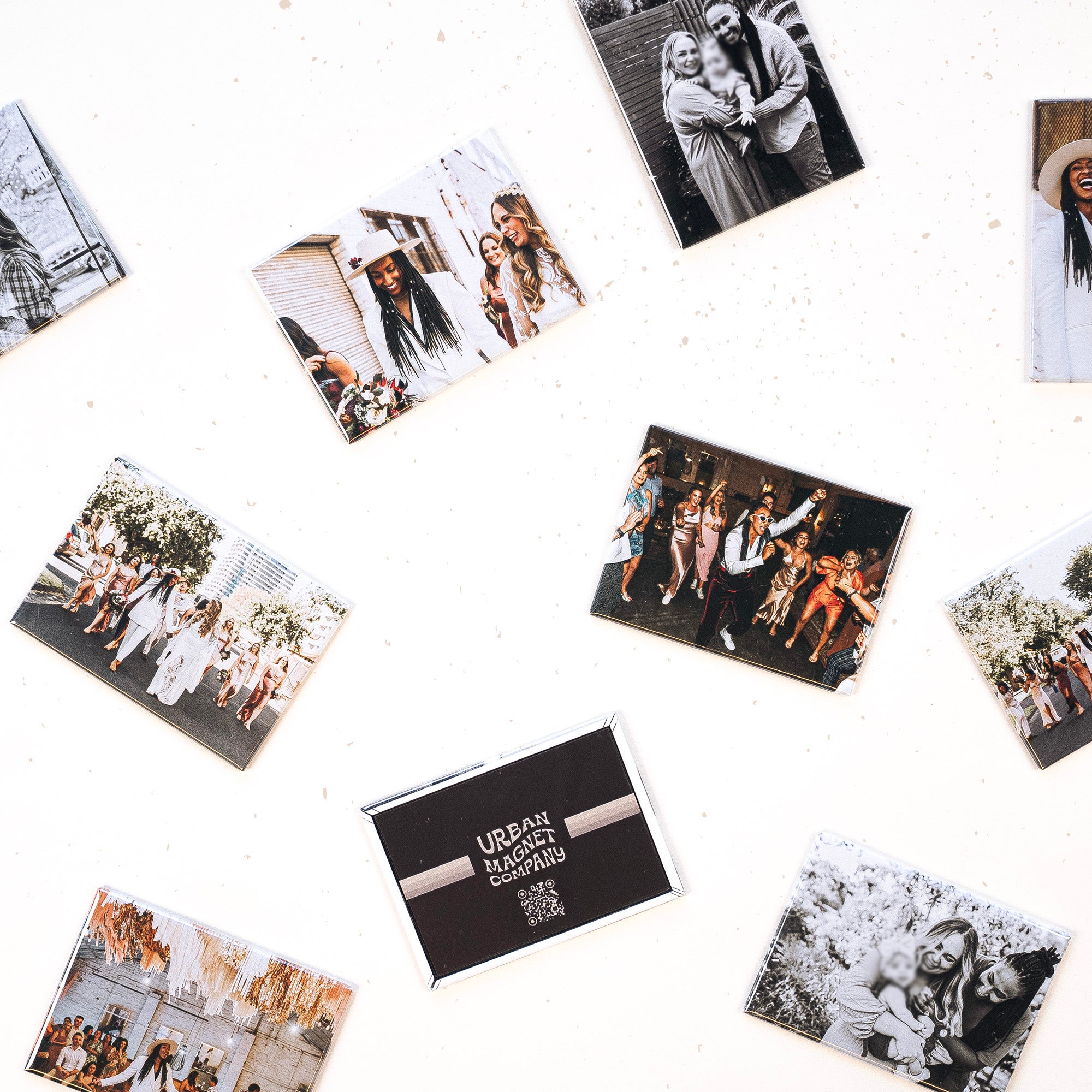 Various magnets spread out over a white background, printed with wedding photos and family photos. 